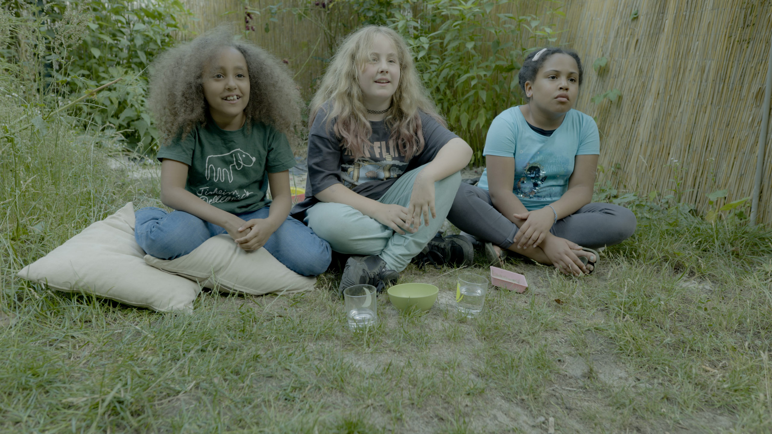 Laura (v.l.), Mila und Zoha beobachten wie die Sonnenblumensprossen im Clip tanzen